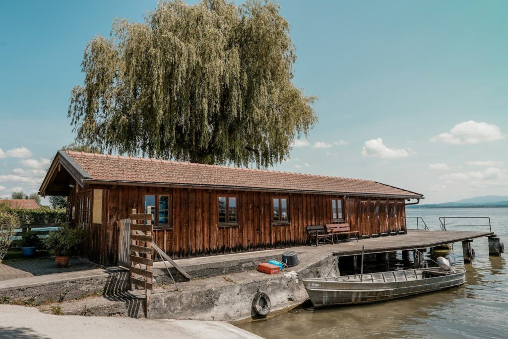 Wooden boathouse with a weeping willow tree and boat